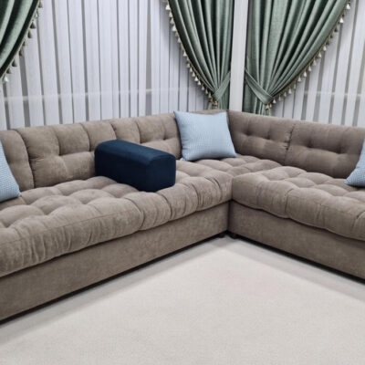 Luxury beige tufted L-shaped corner sectional sofa in modern living room"