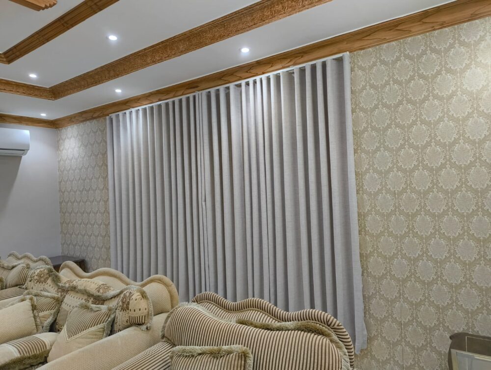 Grey blackout curtains installed across a wide window
